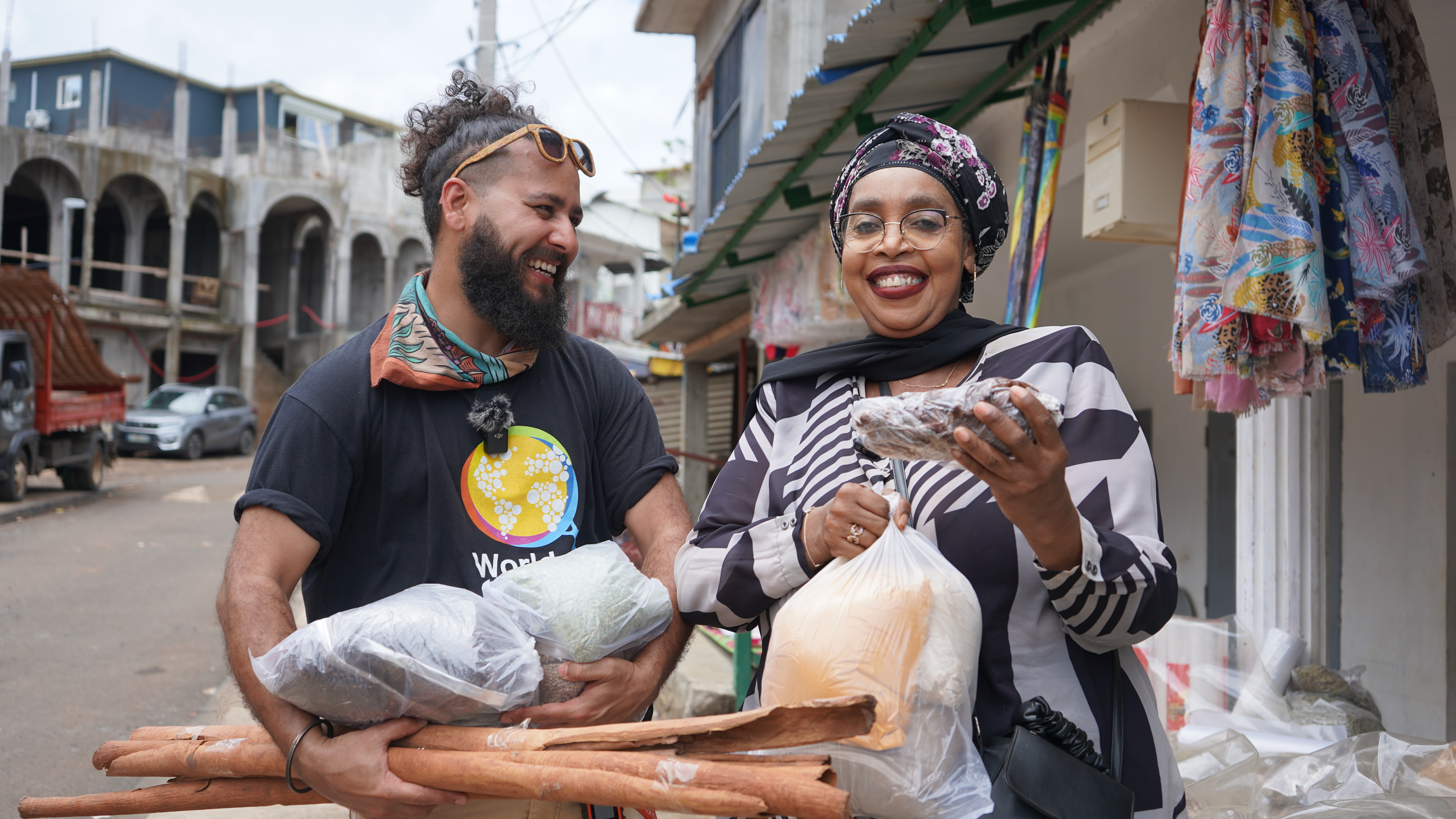 Chef Fatima (right) holds local ingredients outside of a Mayotte market.