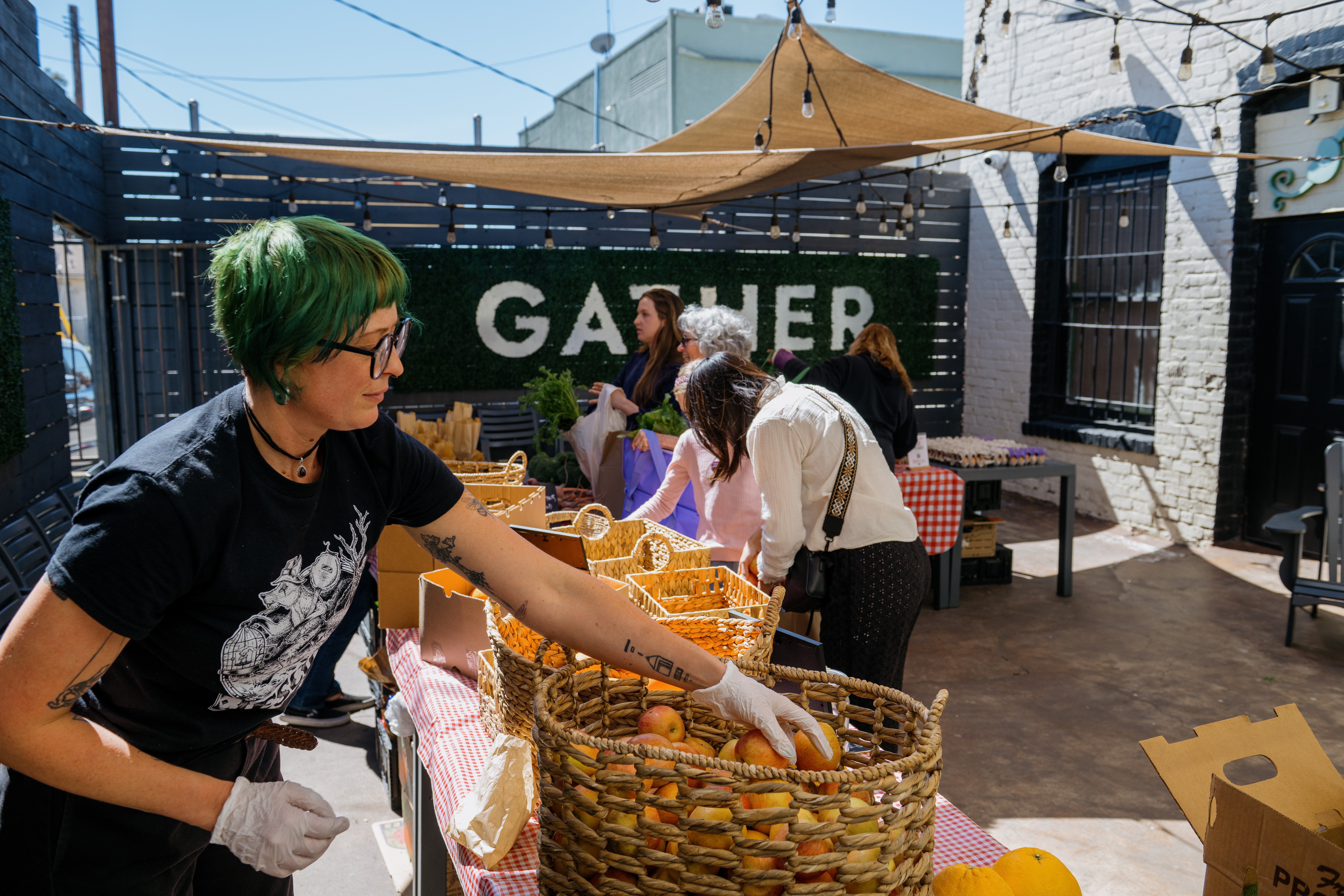 A woman handing out free organic produce at a WCK farmers market in Altadena after the 2024 LA wildfires.