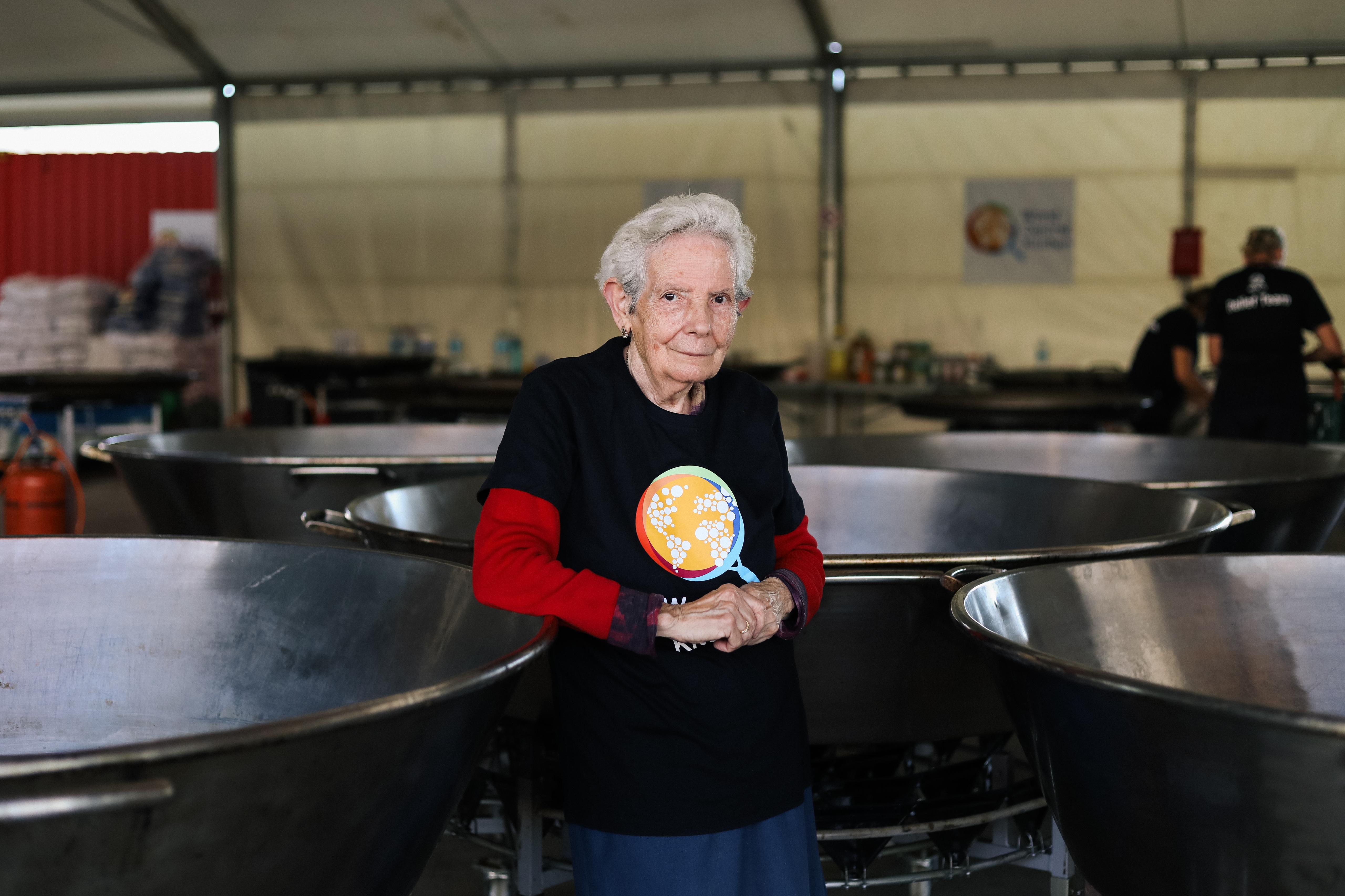 Isabel stands next to a large WCK paella pan inside our Valencia kitchen.