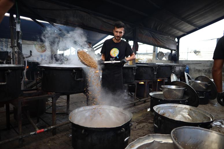 A WCK team member stirs a pot of mujaddara at one of our large capacity kitchens in Gsza.